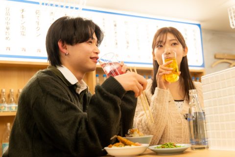 大衆食堂ニューヘイロー 下北沢でドリンクと料理を楽しむ様子